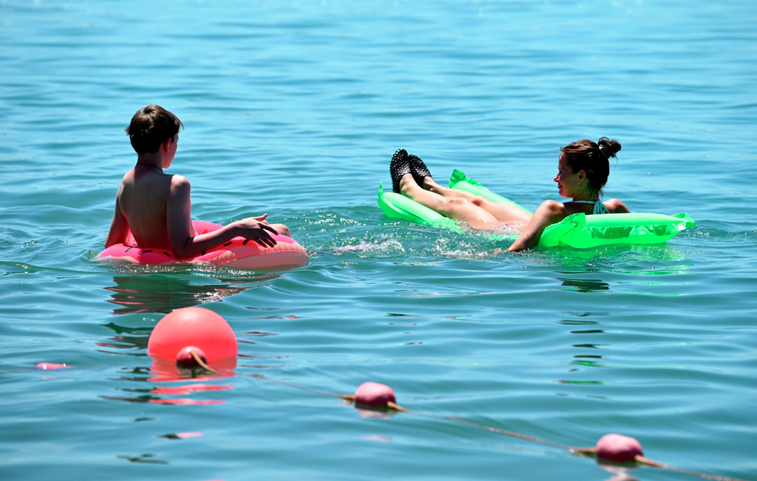 Люди купаются в море на пляже в Сочи. 1 июня в городе официально стартовал летний курортный сезон, открылось 170 пляжей. 