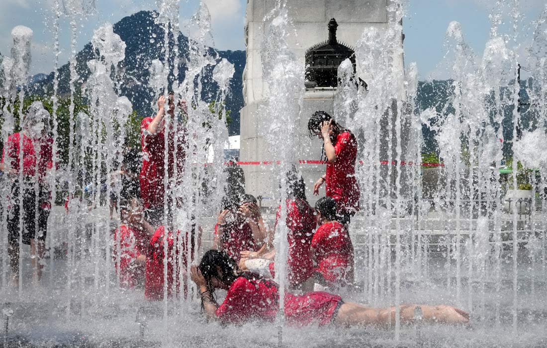Школьники охлаждаются в фонтане в Сеуле
