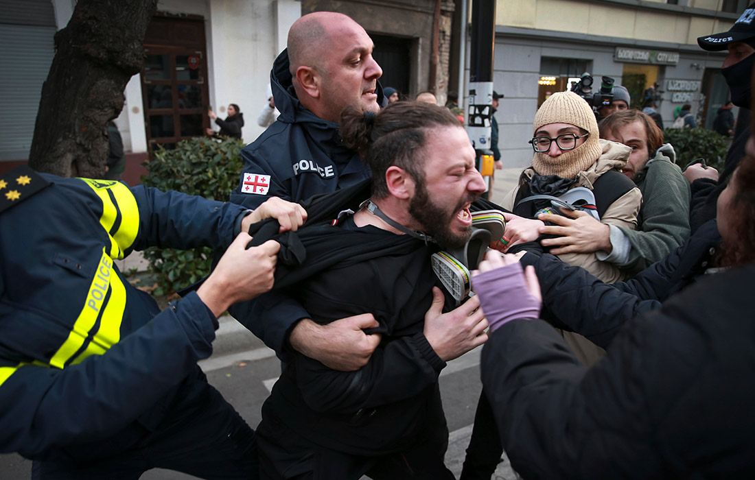 Полиция пытается задержать протестующего во время митинга против результатов парламентских выборов в Тбилиси